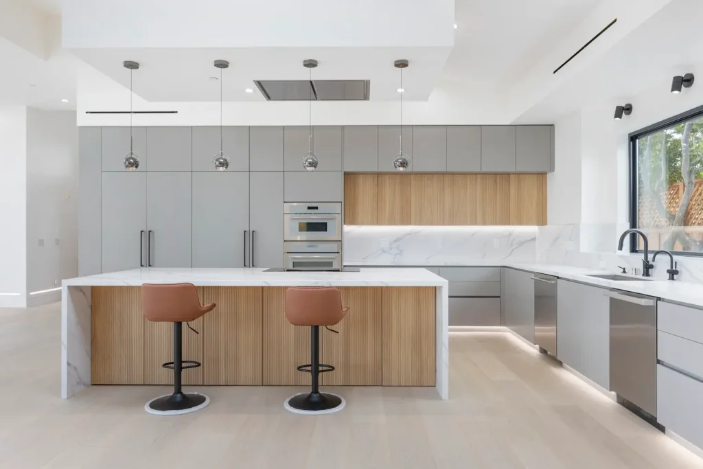 High-end contemporary kitchen with handleless cabinetry, warm wood textures, and a modern island