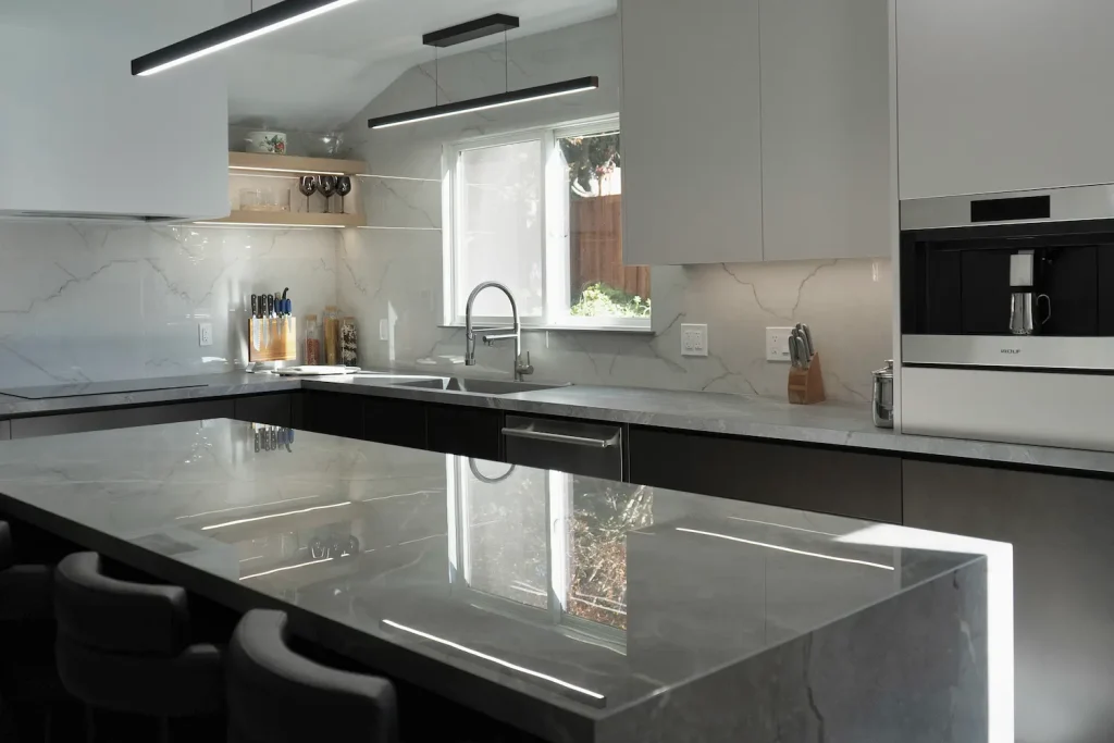 Minimalist modern kitchen with high-gloss finishes, recessed lighting, and a neutral color palette