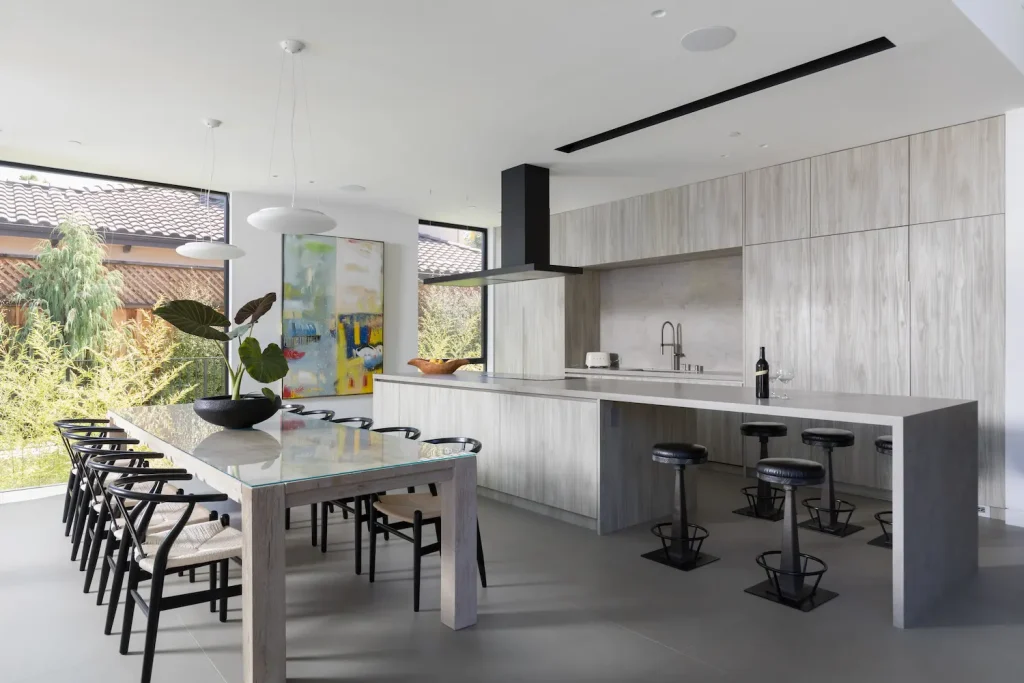 Modern kitchen with an oversized island, black pendant lighting, and a spacious open floor plan