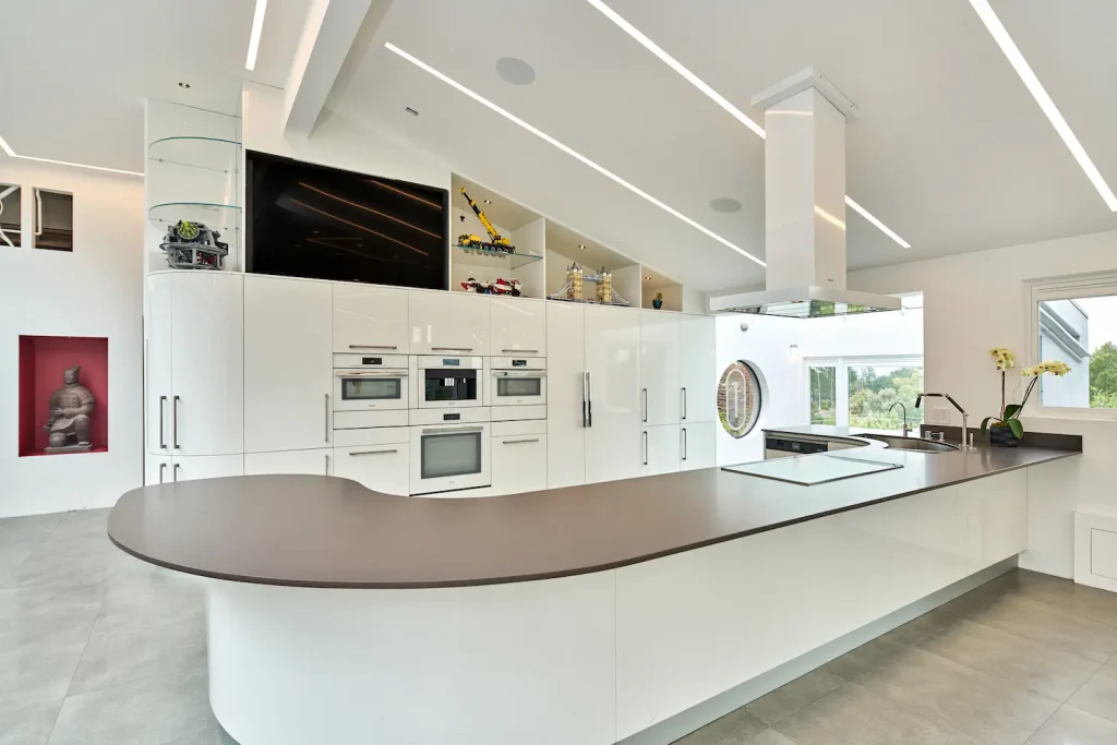 Sleek contemporary kitchen with floor-to-ceiling cabinetry, integrated appliances, and a bold island